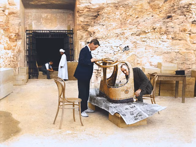 Một phần của cỗ xe được tùy táng cùng với Tutankhamun được các chuyên gia đưa ra khỏi lăng mộ. Dưới ánh nắng Mặt trời, hai chuyên gia kiểm tra tỉ mỉ hiện vật quý hiếm.