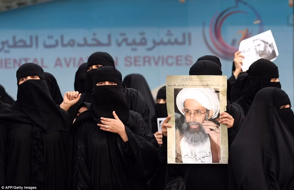 Phụ nữ Ả-rập giương cao ảnh của giáo sĩ Hồi giáo Shiite Nimr al-Nimr tại một cuộc biểu tình tại thành phố Qatif, miền đông Ả-rập Xê-út.