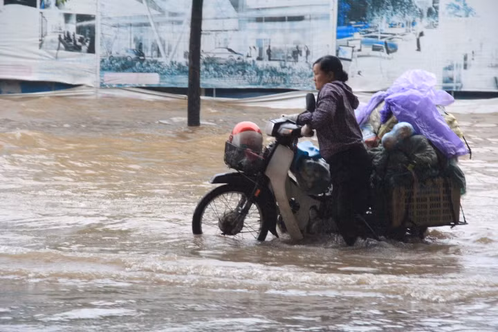 Một phụ nữ phải dong xe hàng vì chết máy. Ảnh: Vũ Thủy.