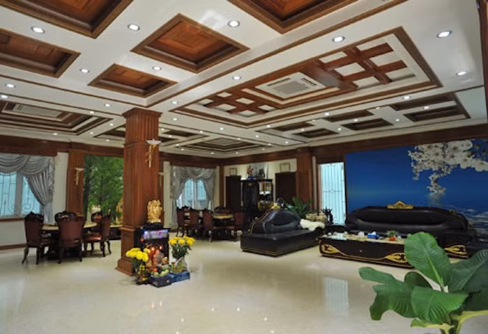 Phòng khách tại tầng trệt rộng rãi với điểm nhấn là trần nhà được thiết kế cầu kỳ, độc đáo.