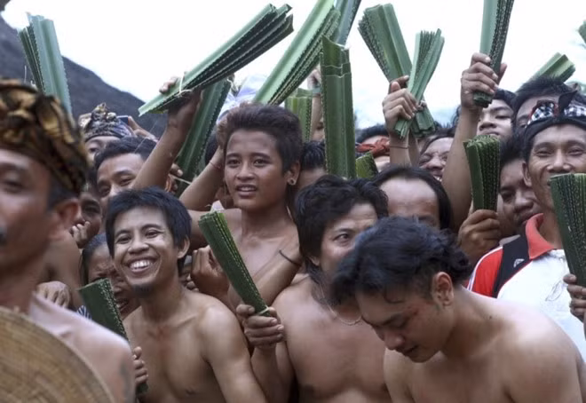 Các thanh niên trên đảo Bali quan sát trận đấu và chờ tới lượt. Dù cảm thấy lo âu hay tự tin, họ luôn mỉm cười.