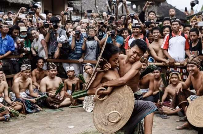 Hai cậu bé chiến đấu hăng say trong sự cổ vũ của dân làng và du khách.