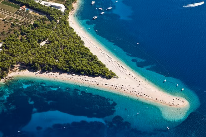 Zlatni Rat, Brač, Croatia: Làn nước xanh biếc và dải rừng thông giữa bãi cát trắng khiến Zlatni Rat là nơi được nhiều du khách chọn làm điểm đến. Bãi biển này còn cho khách được mình trần tắm nắng. Đây cũng là nơi yêu thích của những người mê lướt ván buồm. Bãi biển cũng thường xuyên thay đổi hình dạng theo sức mạnh của gió và dòng biển.