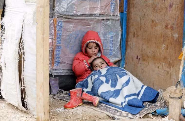 1 cô bé tị nạn người Syria ngồi cùng em trai ở 1 khu vực định cư tạm thời ở thành phố Bar Elias trong thung lũng Bekaa, Lebanon ngày 5/1/2015. 