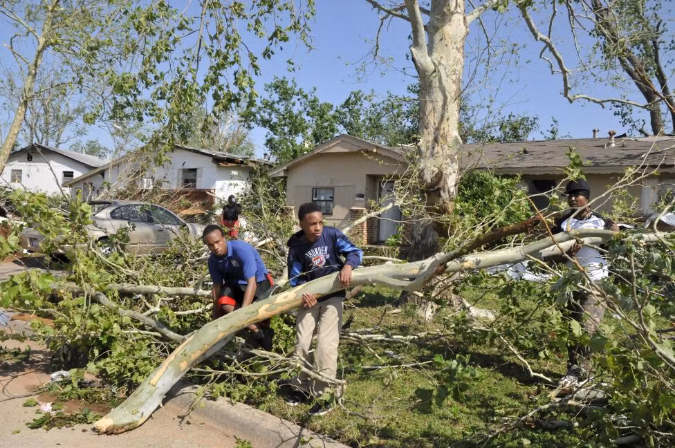 Hình ảnh một gia đình ở Oklahoma đang cùng nhau thu dọn đống đổ nát sau cơn càn quét của vòi rồng.