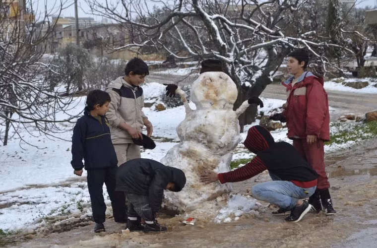 Các cậu bé đang đắp người tuyết ở vùng quê Jabal al-Zawiya thuộc thành phố Idlib, Syria ngày 7/1/2015.