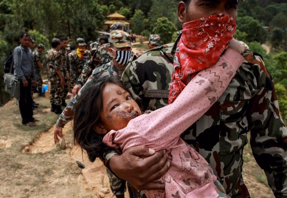 Vụ động đất Nepal đã khiến cho hơn 21.000 thương vong và gây thiệt hại hàng tỷ USD. Trong hình là một bé gái bị thương được đưa ra máy bay trực thăng ở Sindhupalchowk.