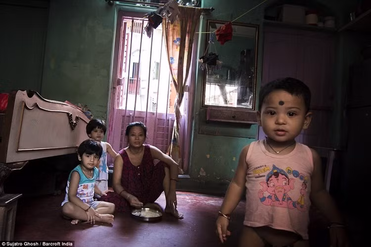 Jyoti (30 tuổi) đang cho các con ăn trưa. Những đứa trẻ sống cùng mẹ ngay trong khu nhà thổ. Nhiều người phụ nữ bán dâm cho biết họ đến đây vì cần tiền để nuôi con ăn học. Con cái họ không thể lớn lên nếu họ không kiếm ra tiền. (ảnh: Barcroft India/DM).