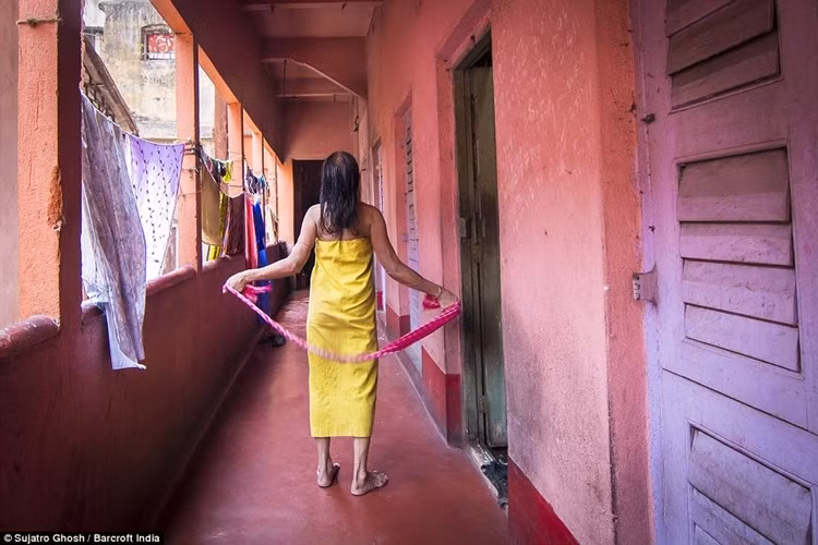 Thậm chí, có những người phụ nữ đã gắn bó với khu phố này suốt cả cuộc đời mình. Trong ảnh là bà Maya Banarjee, 72 tuổi, đang hong khô tóc ở nhà chứa. (ảnh: Barcroft India/DM).