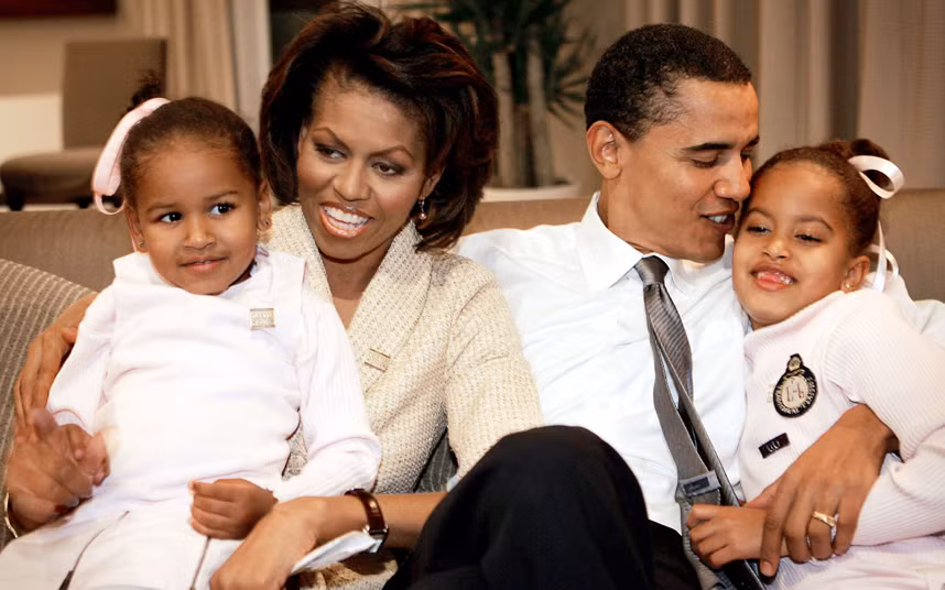 Ông Obama cùng vợ, Michelle Obama, và hai con gái, ngồi trong phòng khách sạn chờ kết quả của một cuộc bầu cử năm 2004.