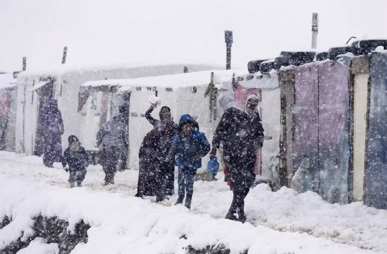 Người tị nạn Syria đi bộ bên ngoài lều khi tuyết rơi ở 1 khu trại tị nạn ở quận Zahle trong thung lũng Bekaa, Lebanon ngày 7/1/2015. 