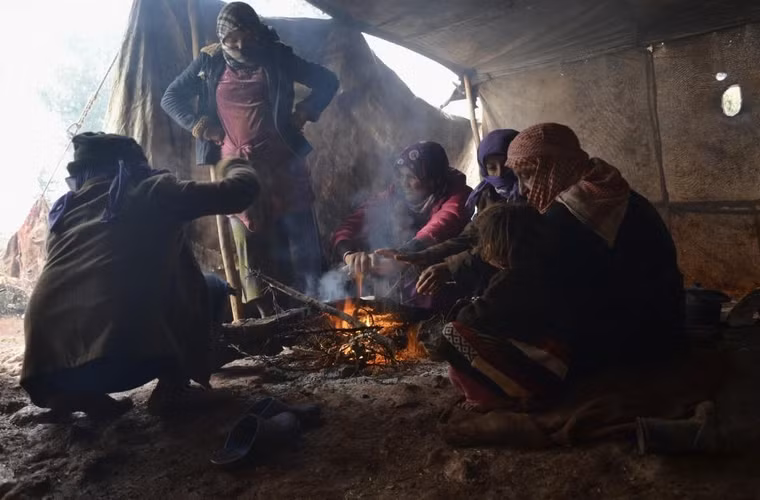 Những người Syria phải sơ tán đang sưởi ấm quanh đống lửa trong lều khi cơn bão mùa đông đang hoành hành ở làng Jabal al-Zawiya, vùng quê phía nam của thành phố Idlib, Syria ngày 7/1/2015.