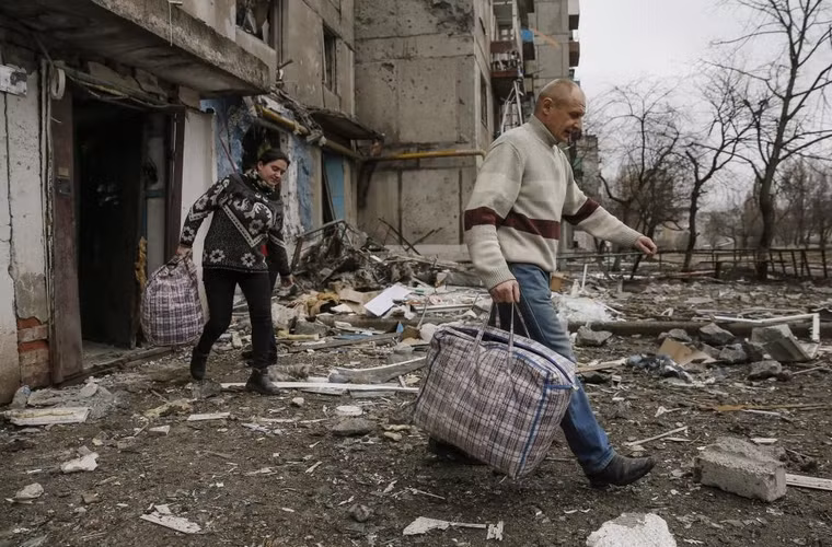 Người dân rời khỏi khu nhà tan hoang ở thành phố Yenakiieve, phía đông bắc Donetsk ngày 2/2/2015.