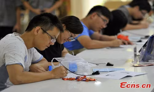 Các thanh niên điền vào giấy để làm thủ tục đăng ký kết hôn. Người Trung Quốc tin rằng 7/7 là ngày mà Ngưu Lang và Chức Nữ gặp nhau sau một năm xa cách.