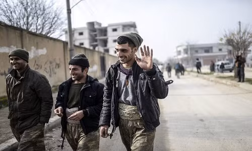 Chiến binh người Kurd đi bộ ở thành phố Kobane.