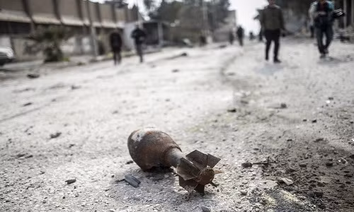 Một quả đạn pháo không phát nổ nằm trên đường đường phố Kobani.