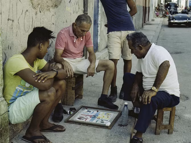 Một nhóm người đang chơi cá ngựa trên đường phố ở Havana. Cờ domino và cờ cá ngựa từng là trò chơi phổ biến nhất ở đây. Nhưng giới trẻ Cuba ngày nay đang chuyển sang chơi điện tử.