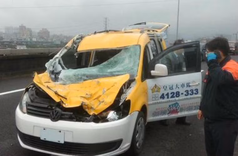 1 chiếc taxi bị móp đầu và vỡ kính trước do va chạm với cánh máy bay lúc rơi xuống.