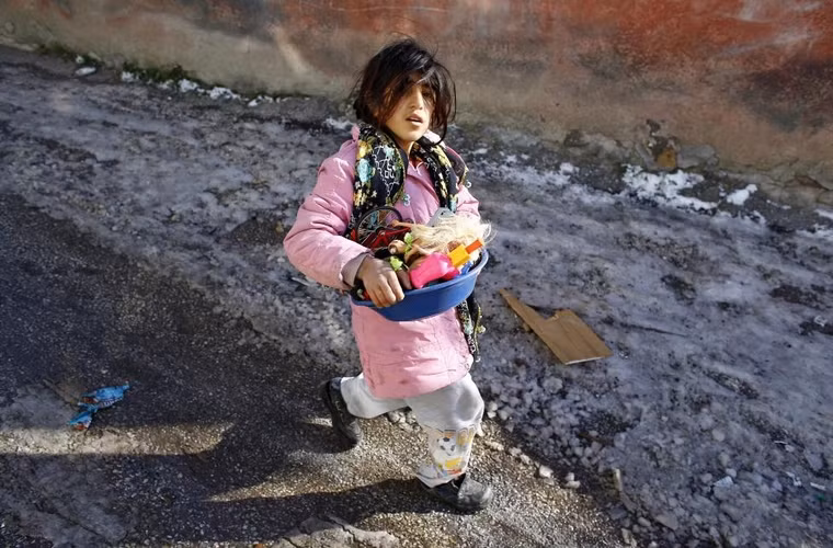  Cô bé tị nạn người Syria mang 1 chậu đồ chơi nhặt được từ những khu vực đổ nát của dân tị nạn Syria ở quận Hacibayram, thuộc thành phố Ankara, Syria ngày 9/1/2015. Nhà chức trách ở thành phố Ankara đã tiếp cận hơn 300 người tị nạn Syria nhằm đưa những gia đình có người có nguy cơ nhiễm bệnh tới các trại tập trung khi mùa đông đang ngày càng khắc nghiệt ngày 9/1/2015.