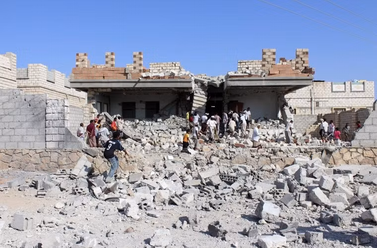 Mọi người tụ tập bên ngoài 1 ngôi nhà bị phá hủy bởi cuộc không kích nghi do al Qaeda chỉ huy ở thành phố al-Shiher thuộc tỉnh Hadramount phía đông nam Yemen ngày 22/11/2013.