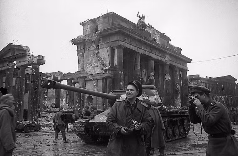 Nhiếp ảnh gia Hồng quân Liên Xô Yevgeny Khaldei (ở giữa) tác nghiệp tại Berlin, Đức. Ông đứng cạnh quân đội Liên Xô gần cổng Brandenburg tháng 5/1945.
