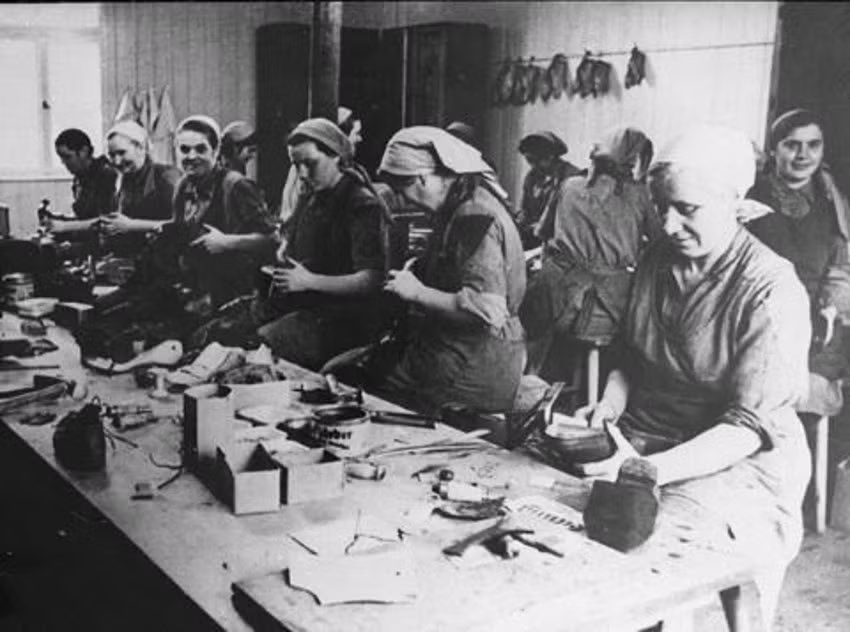 Các nữ tù nhân làm việc trong xưởng sửa chữa, đóng giày tại trại tử thần Ravensbruck.