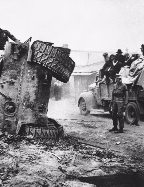 Người lính đứng gần xe tăng Pershing bị lật nghiêng trên đường ngày 14/12/1950. Sau đó, cỗ xe tăng này bị đốt cháy.