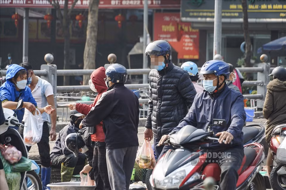 Hàng rong bán rau quả, thực phẩm tràn xuống lòng đường bất chấp lệnh cấm để phòng, chống dịch COVID-19.