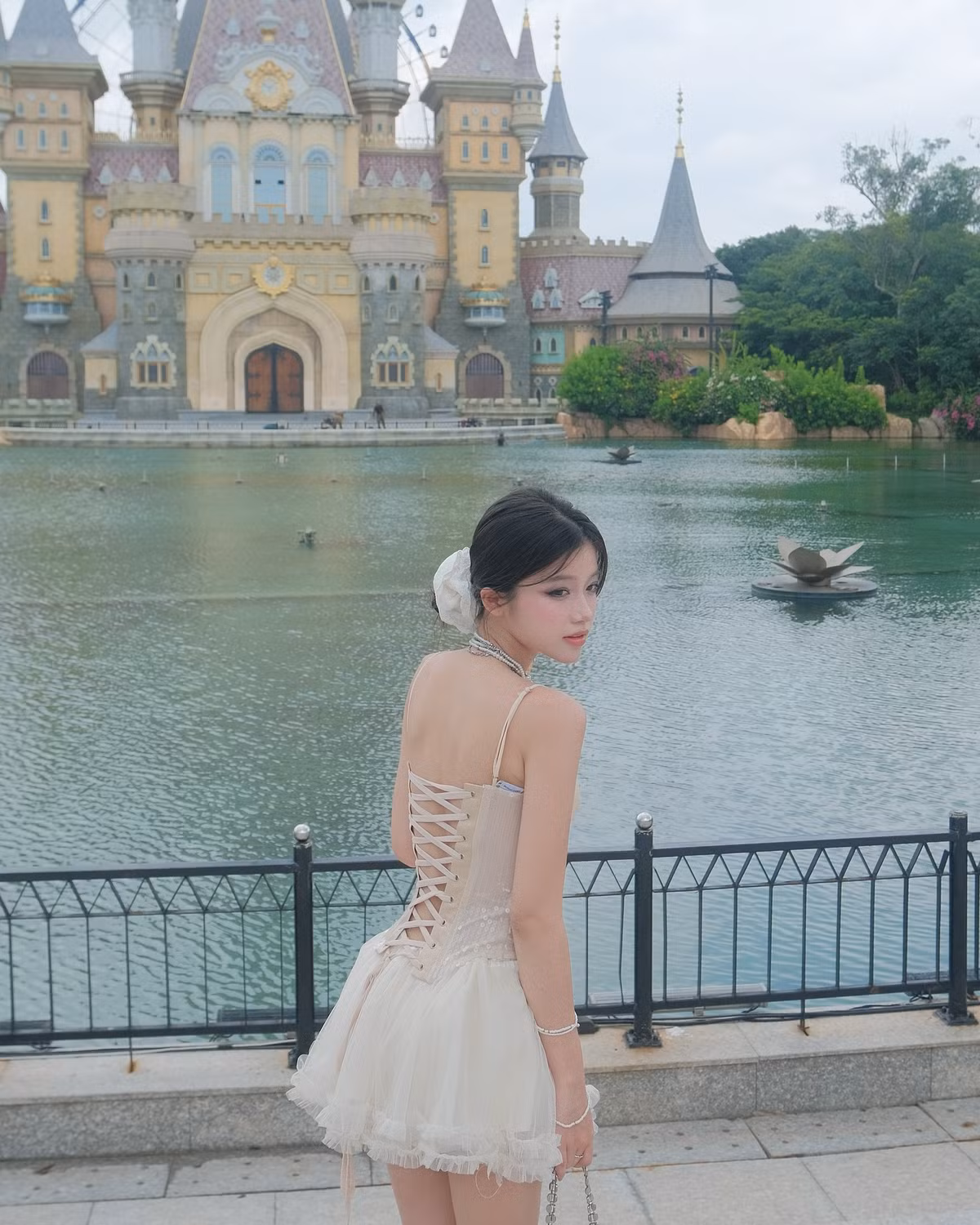 Khung cảnh phía sau là tòa lâu đài tráng lệ được thiết kế theo phong cách châu Âu cổ điển, tạo nên bức tranh hoàn hảo như bước ra từ thế giới thần tiên.