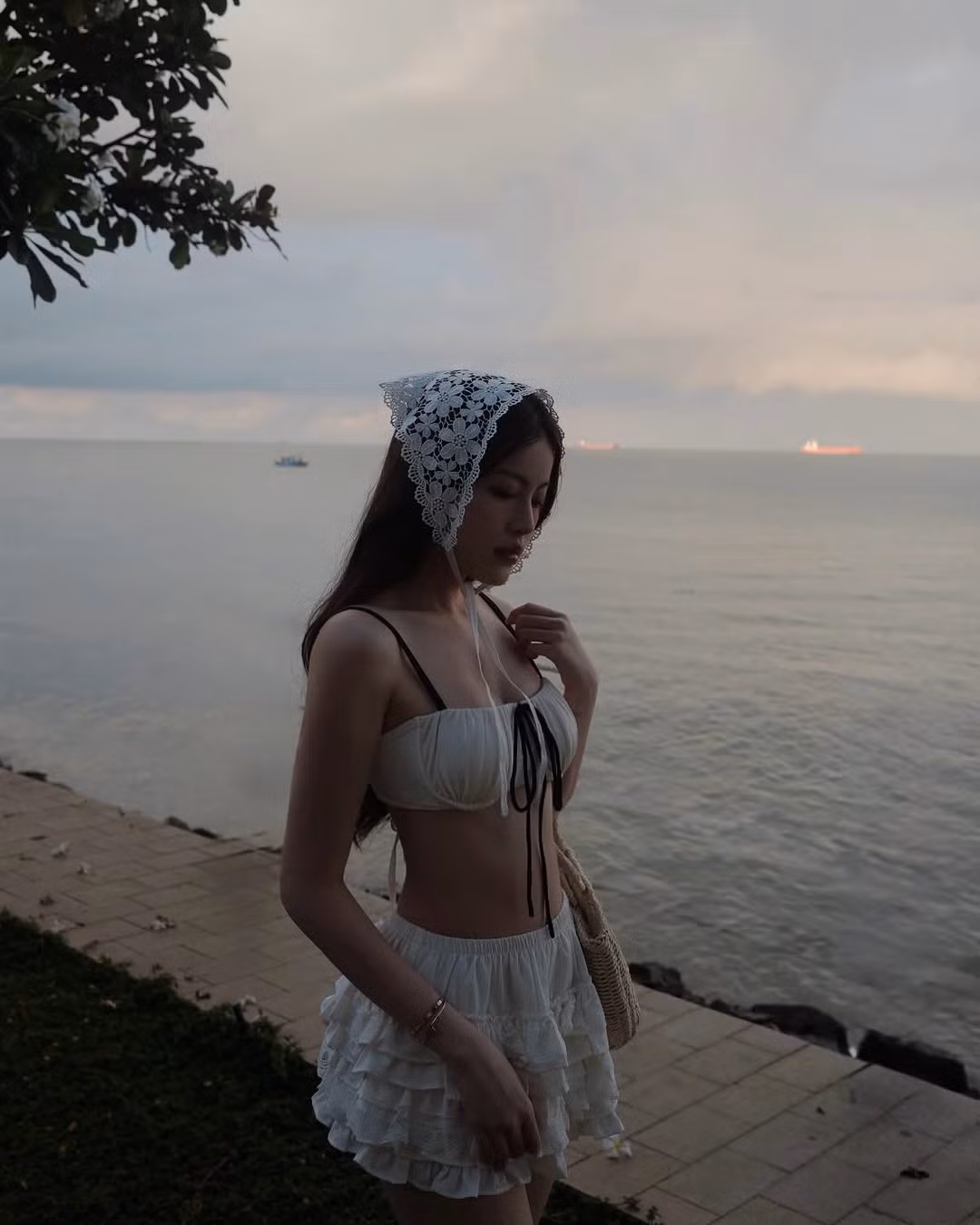 Cô nàng lựa chọn thiết kế bikini trắng dáng bandeau, khoe trọn bờ vai mềm mại và vòng eo con kiến – một trong những điểm mạnh nổi bật trên cơ thể.