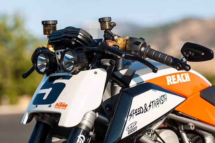 Ở phía trước, phần đầu xe nguyên bản của chiếc môtô KTM Duke 690 đã được Darell thay bằng một tấm chắn bằng sợi thủy tinh, phía trên là một cặp đèn pha đầy "trần trụi. Tay lái cao nguyên bản của chiếc xe được anh thay bằng một cặp tay clip-on đúng kiểu xe thể thao.