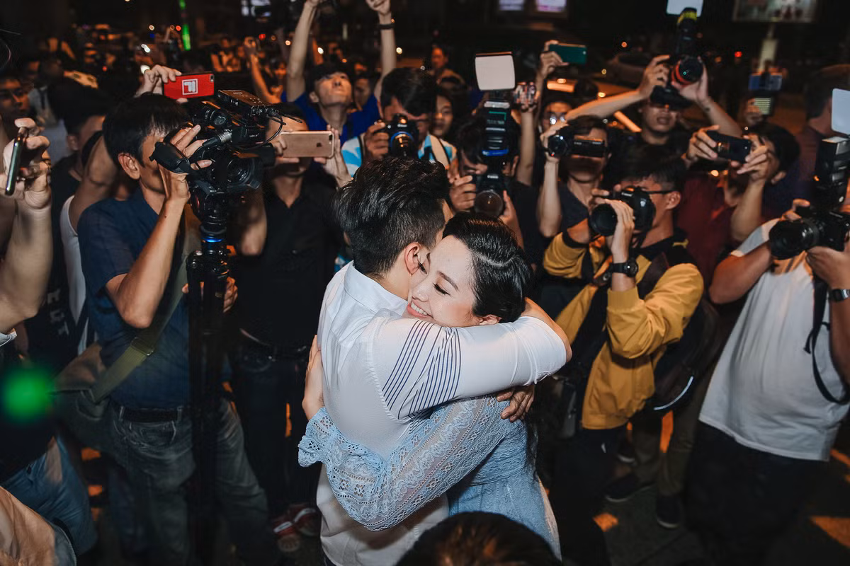 Quốc Cơ ôm chặt vợ giữa vòng vây của ống kính. Trước đó, Hồng Phượng cùng ba mẹ chồng ra sân bay đón ông xã và em trai Quốc Nghiệp từ sớm. Cô chật vật ở sân bay vì con trai hơn một tuổi quấy khóc. Mấy ngày qua, cô kể cậu bé bị ốm sốt nên cô rất vất vả. Vừa căng thẳng chuyện chồng thi đấu lẫn con ốm sốt nên cô cho hay những ngày qua là vô cùng stress.