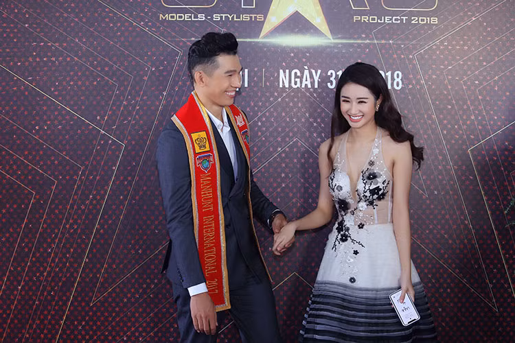 Thu Ngân e dè khi được Nam vương Ngọc Tình nắm tay trên thảm đỏ.