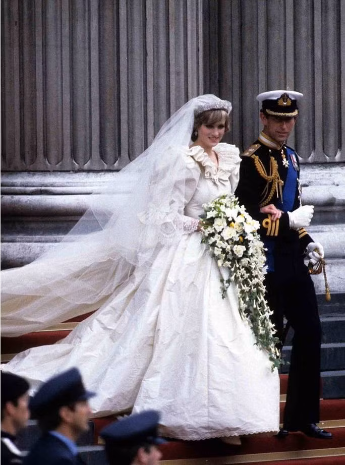 Công chúa Caroline của Vương quốc Monaco mang đúng phong cách thập niên 1970 với điểm nhấn là vòng hoa được trang trí cầu kỳ trên tóc. Bộ váy nữ tính ngọt ngào này đã trở thành một trong những chiếc váy cưới ấn tượng nhất lịch sử hoàng gia châu Âu.
