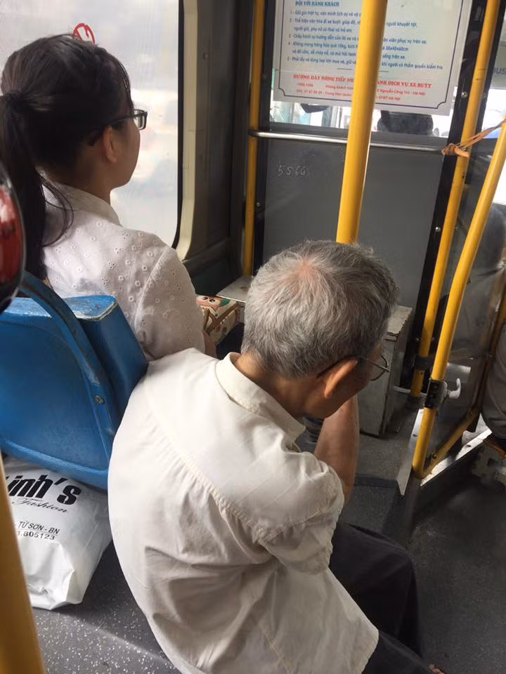 Cụ ông ngồi ghé vào bục để chân trong khi cô gái trẻ không mảy may để ý. Ảnh: Shara Elinna. Cụ ông ngồi ghé vào bục để chân trong khi cô gái trẻ không mảy may để ý. Ảnh: Shara Elinna.