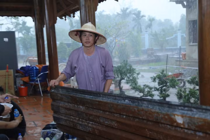 Hoài Linh tự tay dọn dẹp các dụng cụ ngoài sân cũng như kéo bạt che mưa cho khỏi hắt.