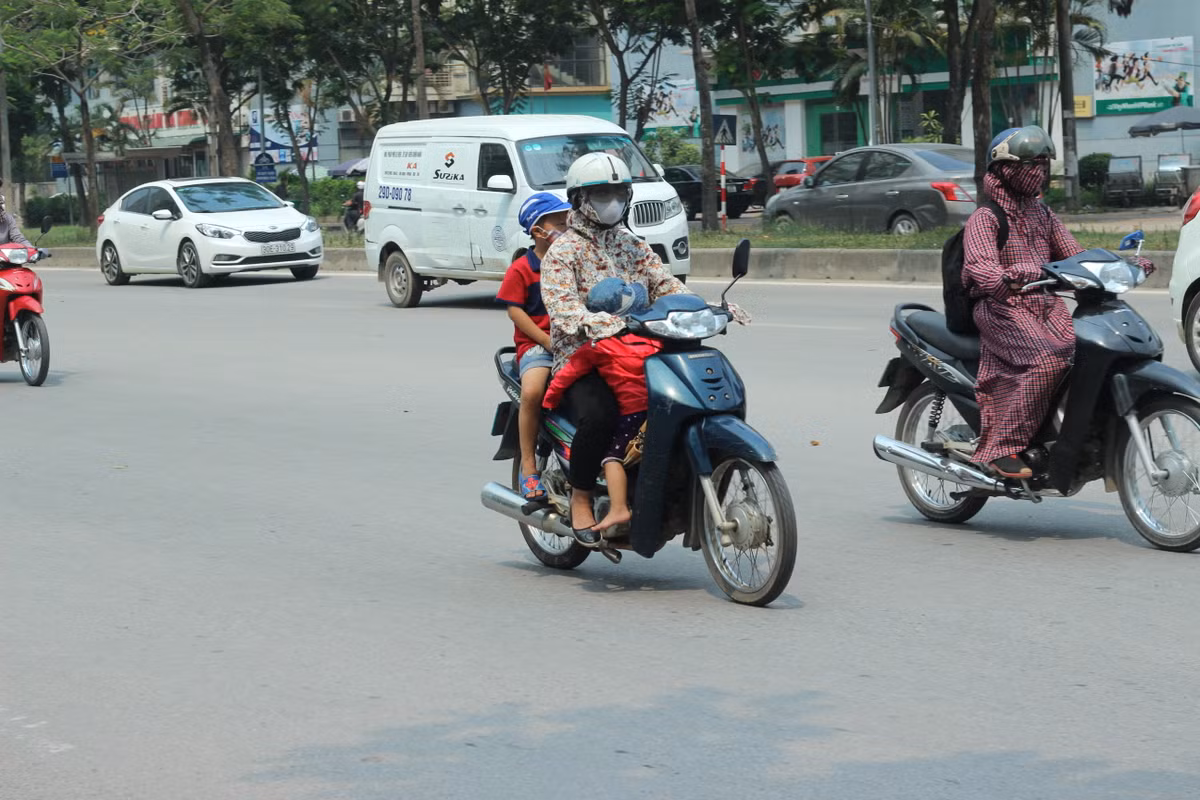 Hình ảnh chụp lại một người phụ nữ chở theo hai con nhỏ đi trên đường Mễ Trì (Nam Từ Liêm, Hà Nội). Tuy nhiên, những người đi đường thót tim bởi người phụ nữ đặt một con mình ngồi dưới khung xe máy, quay mặt về phía sau ngủ vô cùng nguy hiểm.