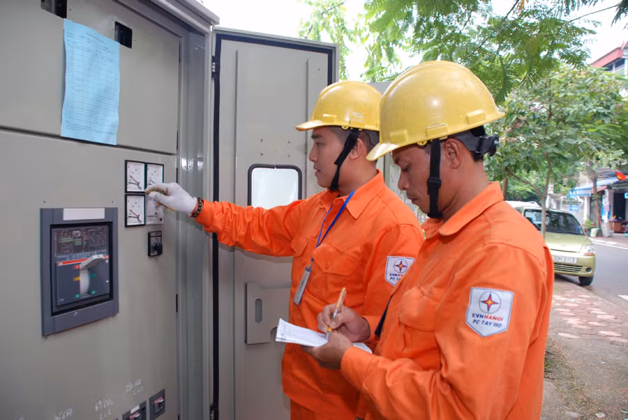 Công nhân Công ty Điện lực Tây Hồ kiểm tra tình trạng làm việc tại trạm biến áp Nhật Tân 20 - Ảnh: Hoa Việt Cường.