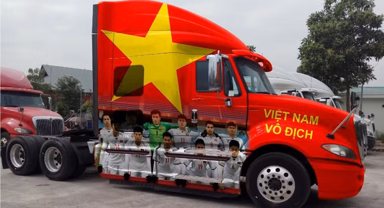 Một chủ phương tiện xe đầu kéo container đã bày tỏ tình yêu bóng đá nước nhà bằng cách bỏ ra hàng chục triệu đồng để sơn lá cờ đỏ sao vàng cực lớn và dán hình các cầu thủ U23 Việt Nam.