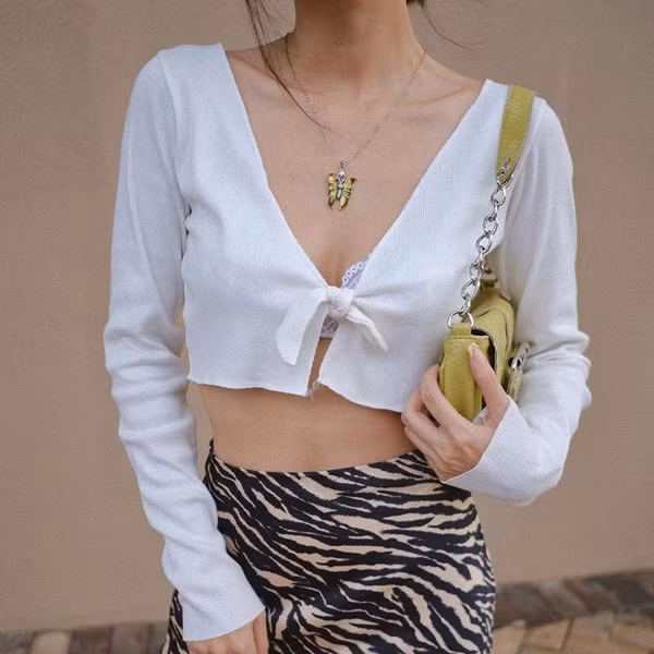 Ngoài khoe được vòng eo phẳng lỳ, mốt thời trang áo croptop buộc dây còn giúp người mặc thu hút sự chú ý nhờ vòng 1 lấp ló.