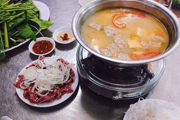 Tiếp đó, đặt lẩu nước trên bếp than, lấy vợt lọc kỹ cơm mẻ, bỏ xác. Nêm gia vị vừa ăn là hoàn thành phần nước lẩu chua dịu đê mê. Khi ăn, cùng với các loại rau, nước chấm cơm mẻ chua ngọt, miếng thịt như hòa tan trong miệng, thấm đều vị ngọt, cay thơm mà mềm ngon hấp dẫn. Ảnh: Internet.