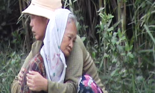 Người phụ nữ ngồi trên đường Đỗ Xuân Hợp, quận 9 ôm chặt cụ bà vào lòng, trần tình đây là mẹ của bà ta đang bị ung thư, kiệt sức.