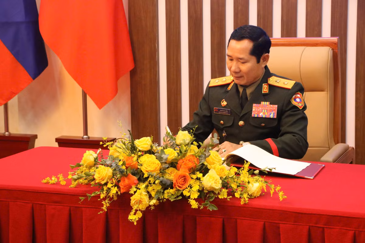 Trung tướng Saichay Kommasith ghi sổ vàng lưu niệm.