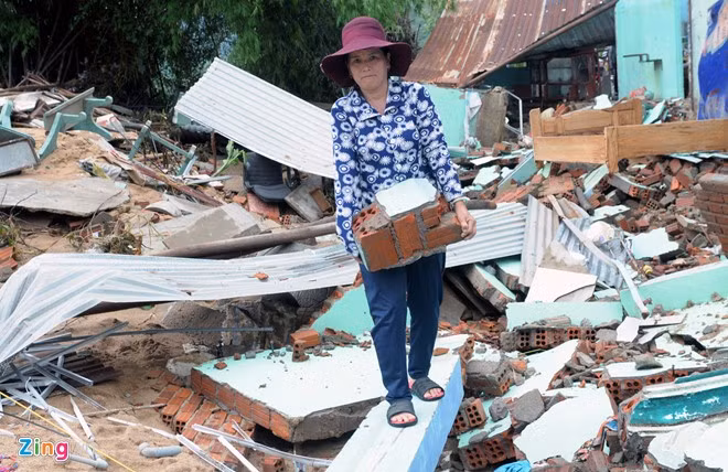 Tranh thủ lũ rút, bà Lê Thị Mỹ (ngụ thị trấn La Hai) thu dọn đống gạch vỡ trong căn nhà đổ nát do lũ lớn giật sập.